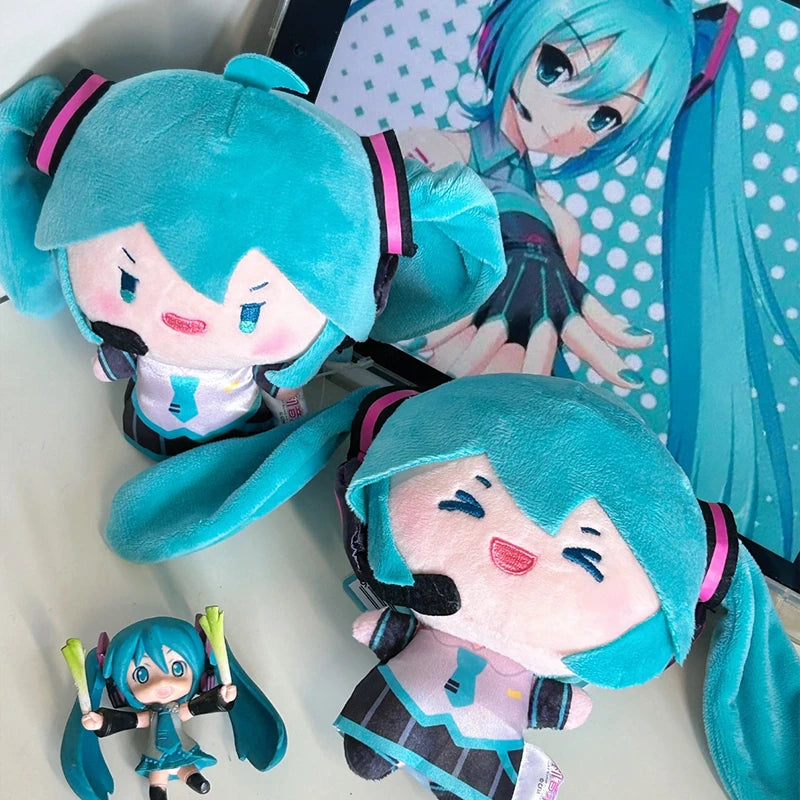 A plush keychain of an anime girl with bright blue hair and a pink outfit.