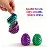 Hand twisting a purple dragon egg fidget toy into a green one, showing silky smooth texture.