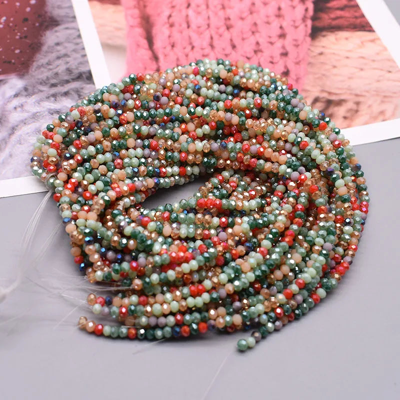 A thick strand of multicolored faceted crystal rondelle beads in shades of green, pink, and amber for jewelry making.