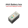 A gray AAA battery box with an orange switch and a green indicator light.