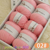 A box of pink wool yarn balls for knitting, showing various skeins and a label indicating Woolyarn.