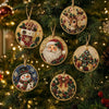 A close-up of various Christmas diamond painting ornaments hanging on a green fir tree.