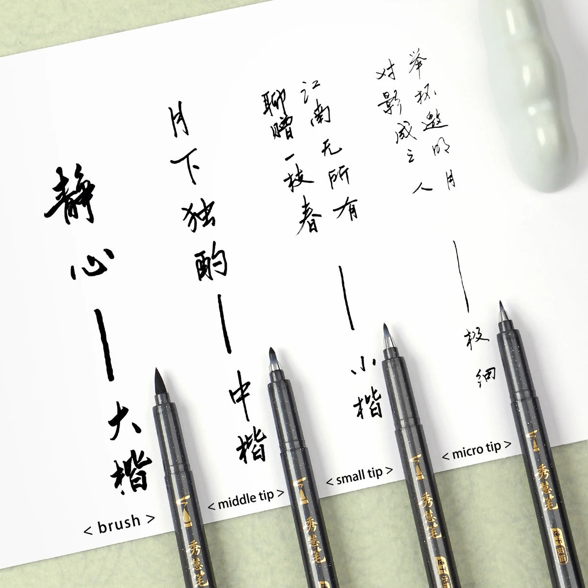 A set of four brush pens for calligraphy featuring soft weasel-hair tips on a white paper.