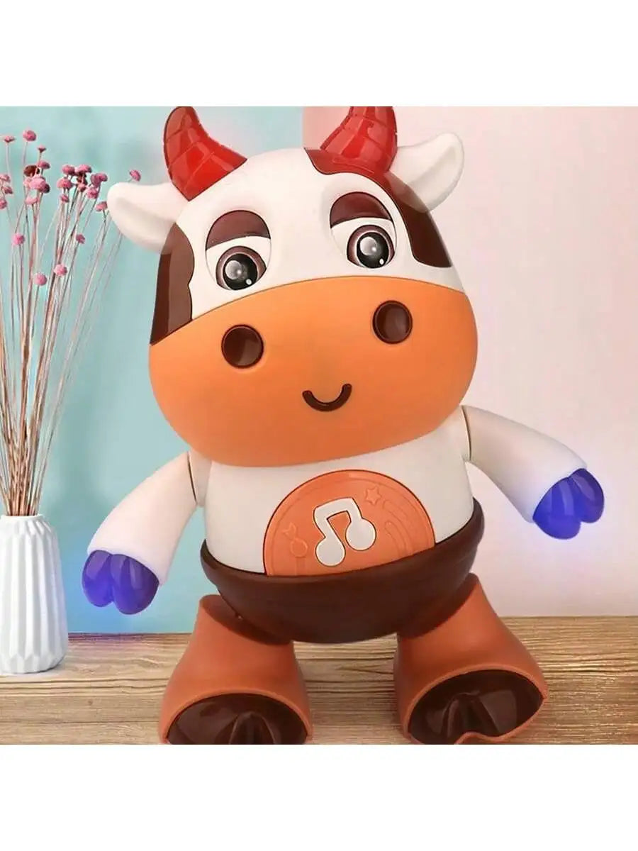 A plush toy of a cow with horns and musical notes on its body, standing on a wooden surface.