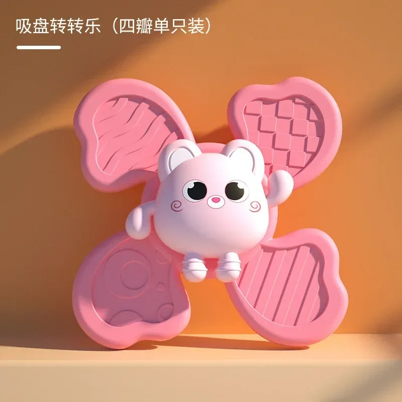 A pink suction cup spinner bath toy shaped like a cute white animal for toddlers.
