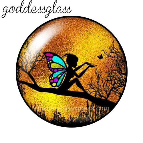 A round glass cabochon with a vibrant orange and yellow gradient background featuring a silhouette of a winged figure against