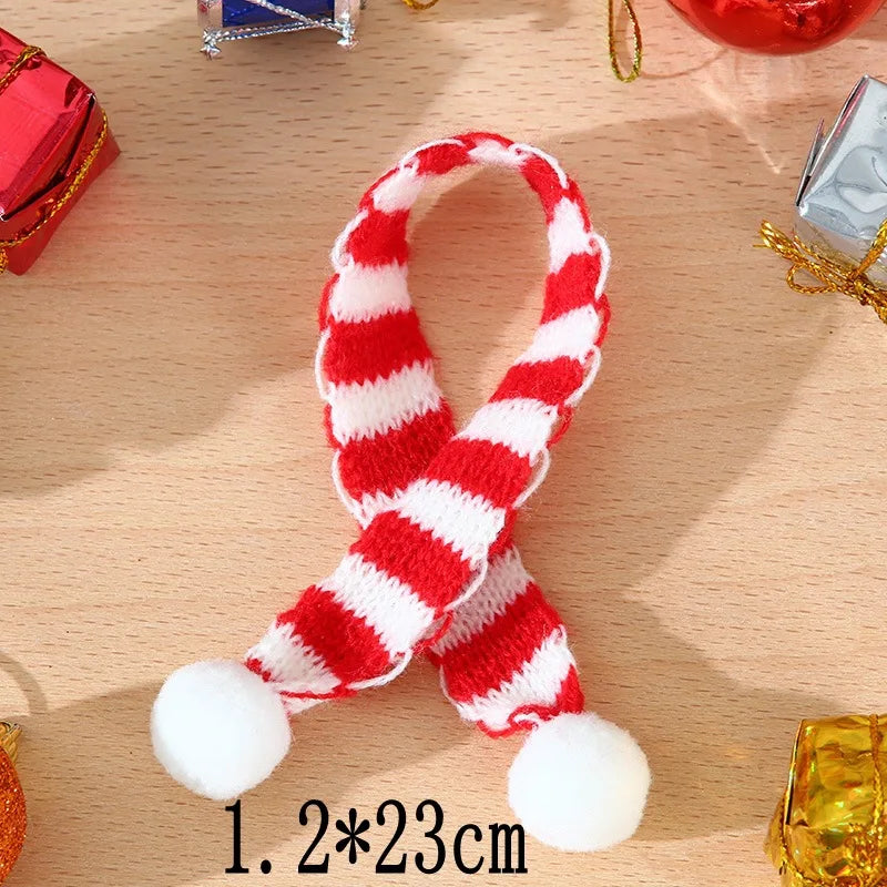 A red and white striped knitted hat and scarf set for dolls displayed on a wooden surface.
