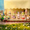 A display of Lulu the Piggy Garden Series collectible figurines in various colors and sizes arranged on a wooden shelf.