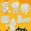 A collection of unfinished wooden Halloween hanging ornaments featuring a witch, a monster, a globe, and a bat-eared cat on a