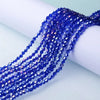 A close-up of deep blue faceted crystal beads strung together, laid out on a white surface.
