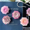 Pink flower silicone mold for crafting with a white beaded necklace and green bottle