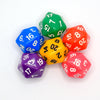 A collection of six polyhedral dice in various colors including green blue red and purple resting on a white surface.