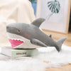 A gray and pink plush stuffed animal depicting a killer whale and great white shark.