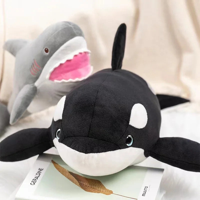 A black and white plush toy depicting a killer whale and a great white shark.