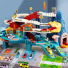 A dinosaur rail car adventure playset featuring a red and yellow track, building elements, and a parking lot area.