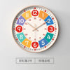A round analog clock face with colored numbers and hands, featuring a red and gold design.