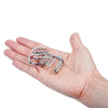 A hand holds an 8-piece metal brain teaser puzzle set consisting of interlocking rings.