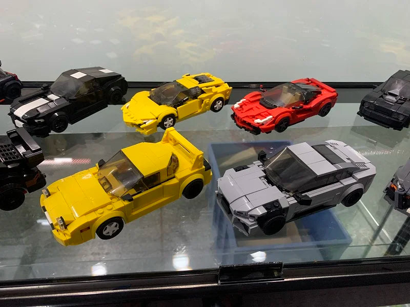 A display of various yellow, red, and gray classic supercar building blocks set for adults.
