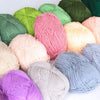 A collection of pre-dyed milk cotton yarn in various shades of green, pink, yellow, and purple.