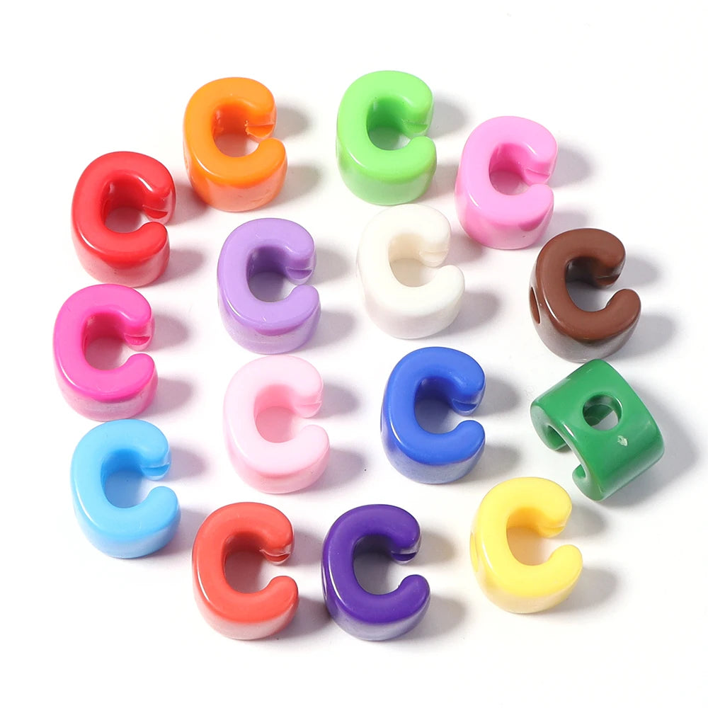A collection of colorful acrylic capital letter beads in various shades including orange, green, pink, purple, white, and yel