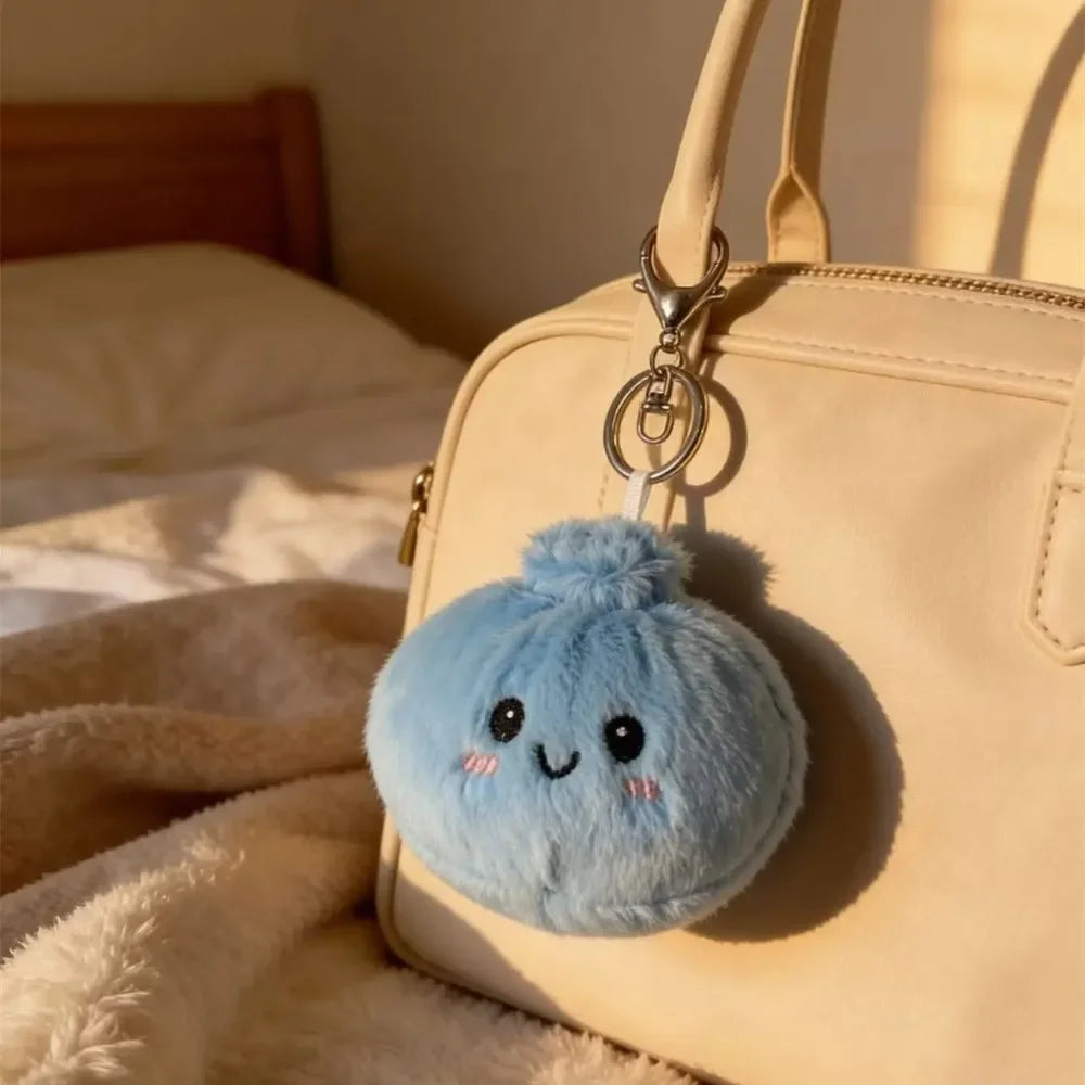 A light beige handbag with a blue squishy dumpling keychain plush attached to the zipper pull.