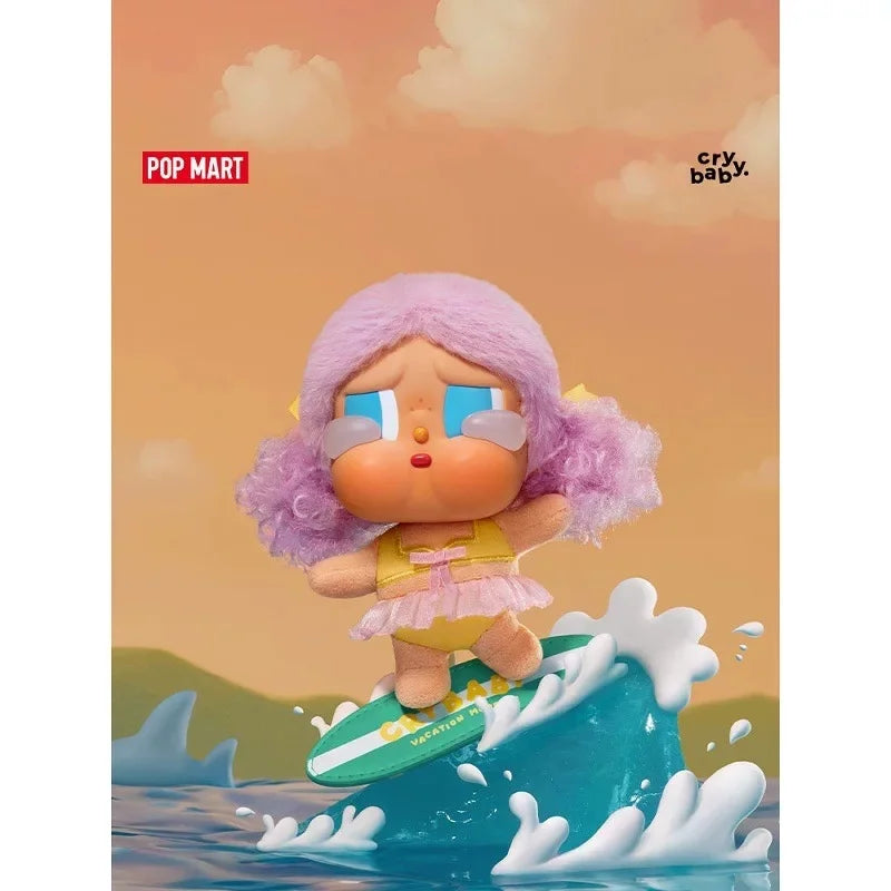 A pink-haired Crybaby Vacation Mode on vinyl figure is shown emerging from blue water.