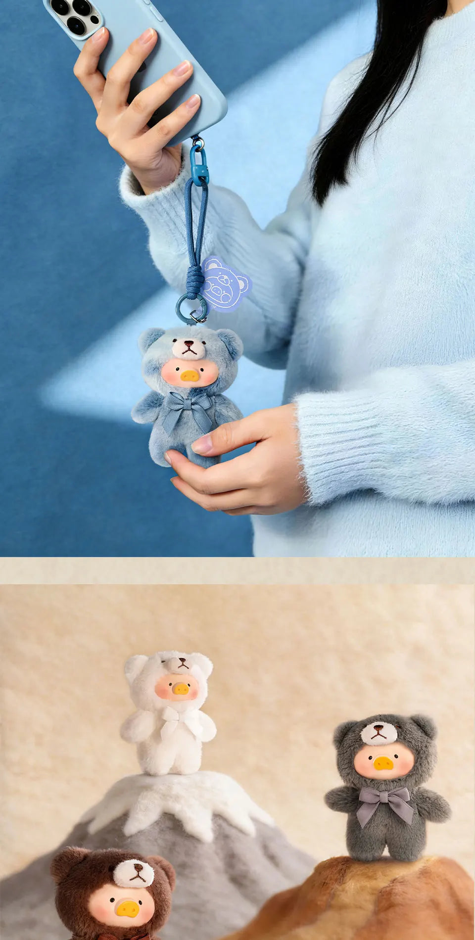 A small, gray teddy bear is attached to a phone strap and held by a person against a blue background.