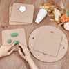 Hands are using a pottery tool to shape clay on a round wooden pottery wheel.