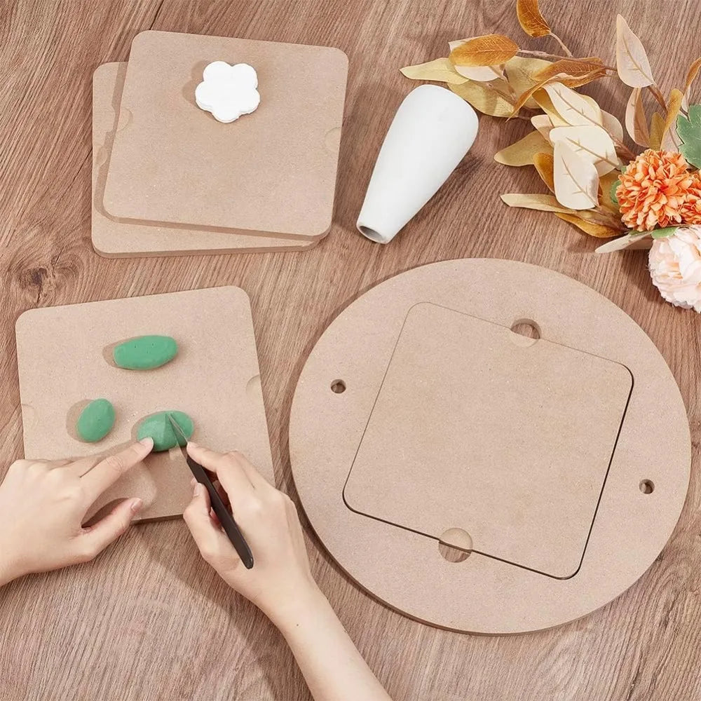 Hands are using a pottery tool to shape clay on a round wooden pottery wheel.