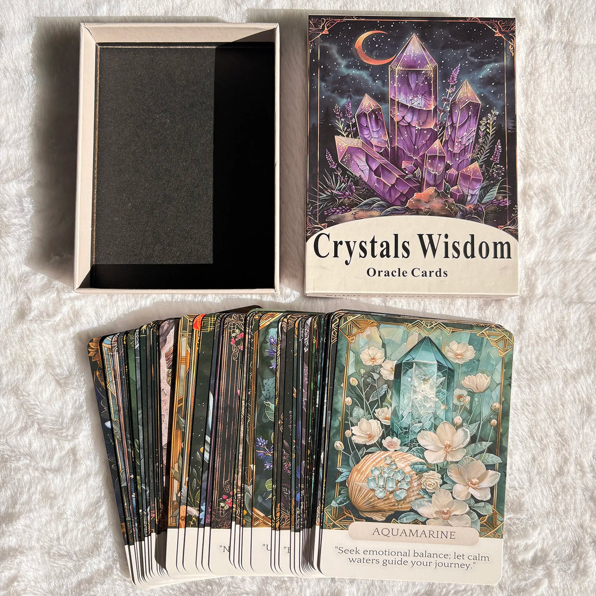 A deck of Crystals Wisdom Oracle Cards featuring a dark background and purple crystals, displayed next to a framed card and a