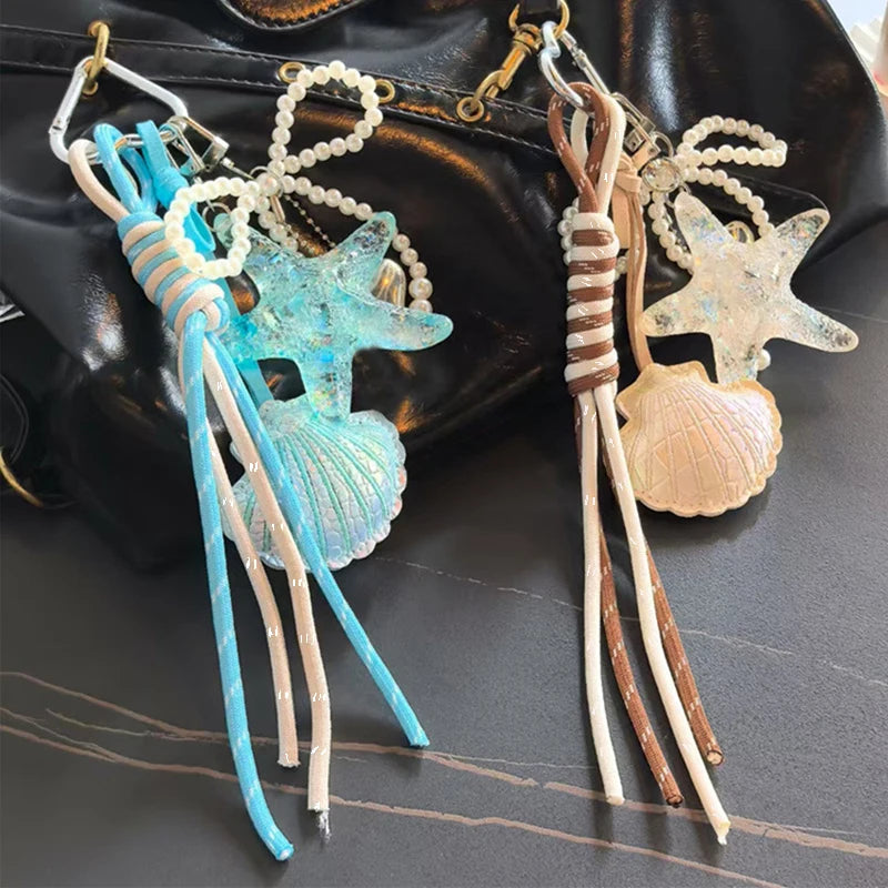 A set of beaded keychain charms featuring sea creatures and shells on a dark leather background.