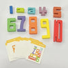A set of wooden number building blocks in various colors and double-sided cards for early math learning.