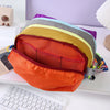 A stack of colorful alpaca themed travel storage bags in shades of orange, yellow, and gray resting on a white surface.