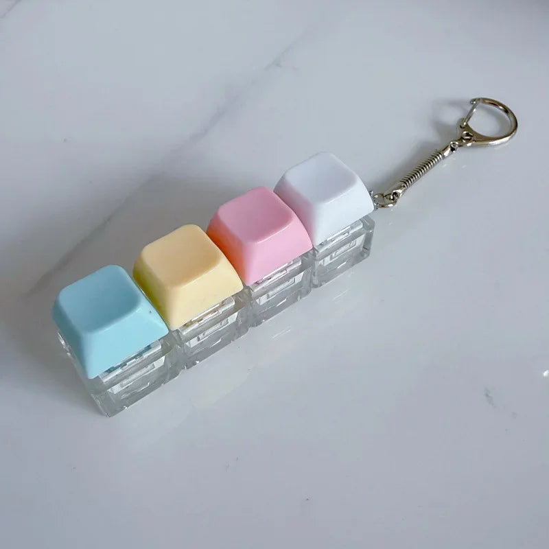 A clear plastic keychain organizer filled with colorful fidget cubes, including white, pink, yellow, and light blue.