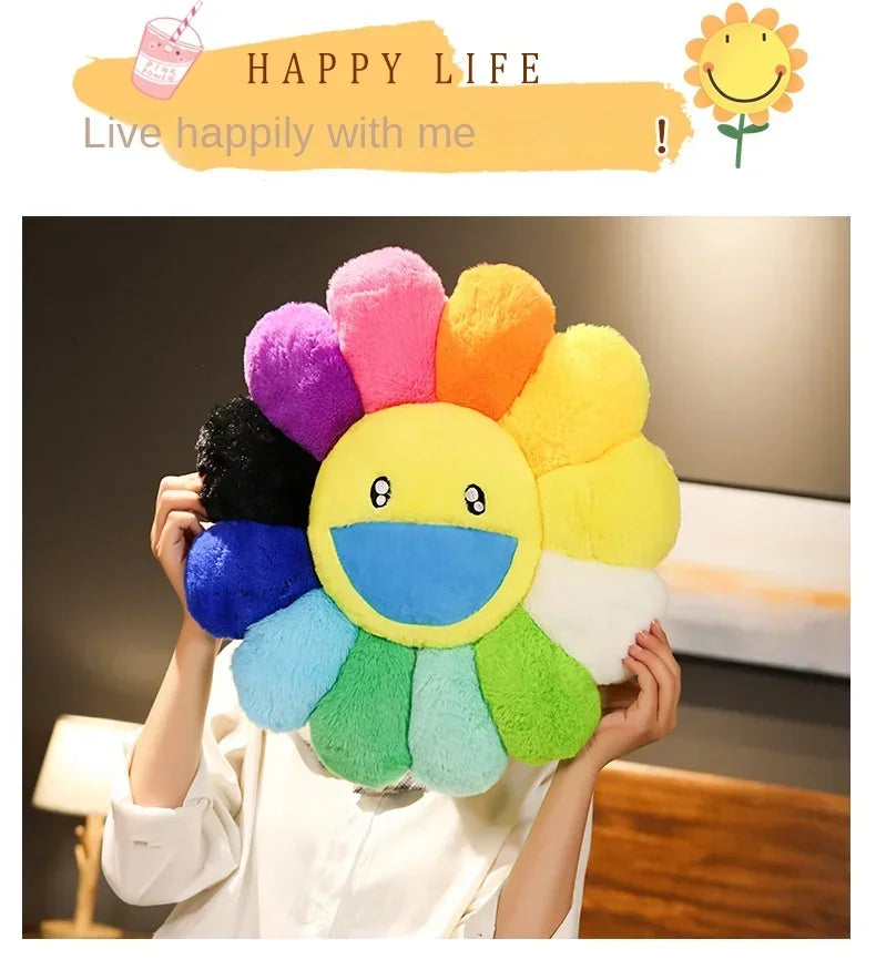 A person is holding a large, colorful sunflower plush cushion with bright petals and a smiling face.