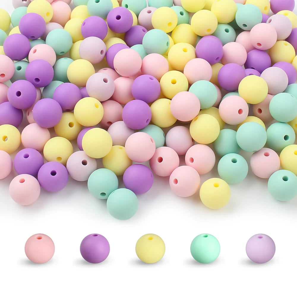 A pile of round, flexible silicone beads in various pastel colors including pink, yellow, purple, and green.