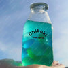 A glass bottle filled with bright blue liquid is held in a person's hand.
