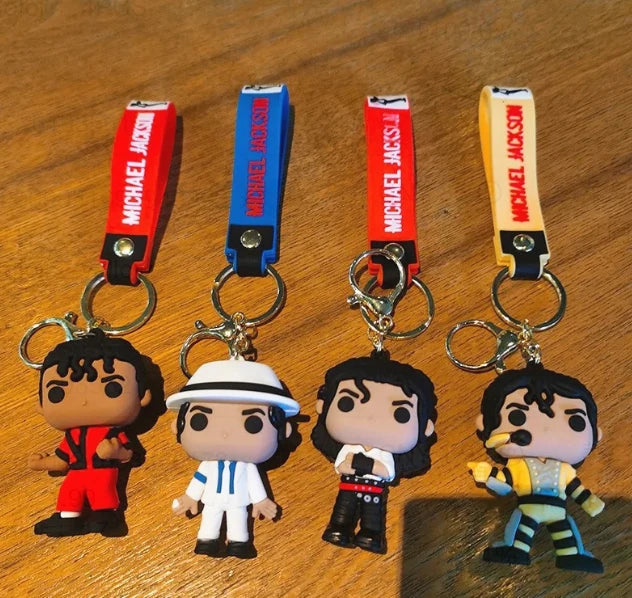 A set of keychains featuring figures of Michael Jackson in various poses and outfits attached to metal buckles.