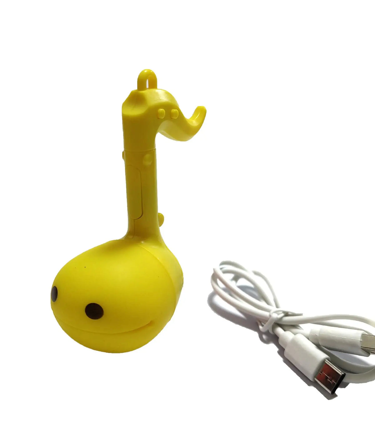 A yellow Otamatone mini electronic musical instrument toy with a white cord.