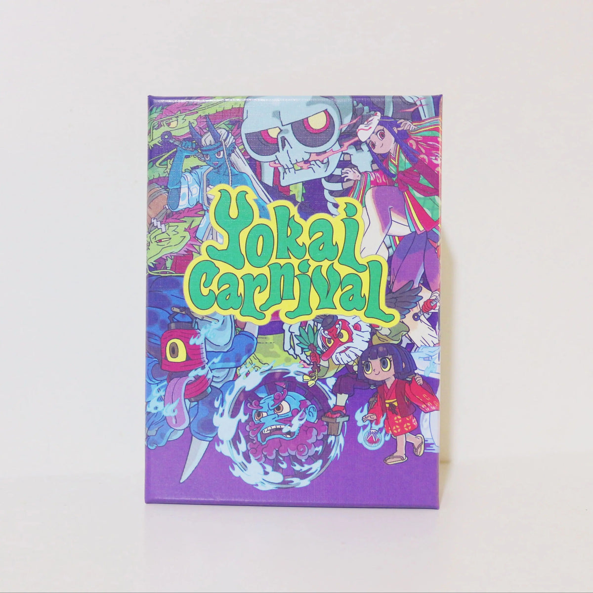 Box art for the Yokai Carnival strategic board game featuring stylized characters and vibrant colors.