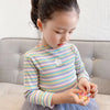 A young girl wearing a striped floral print cotton t-shirt and a tulle skirt is looking down.