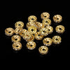 A collection of gold-toned crystal rondelle spacer beads for jewelry making, arranged on a black surface.
