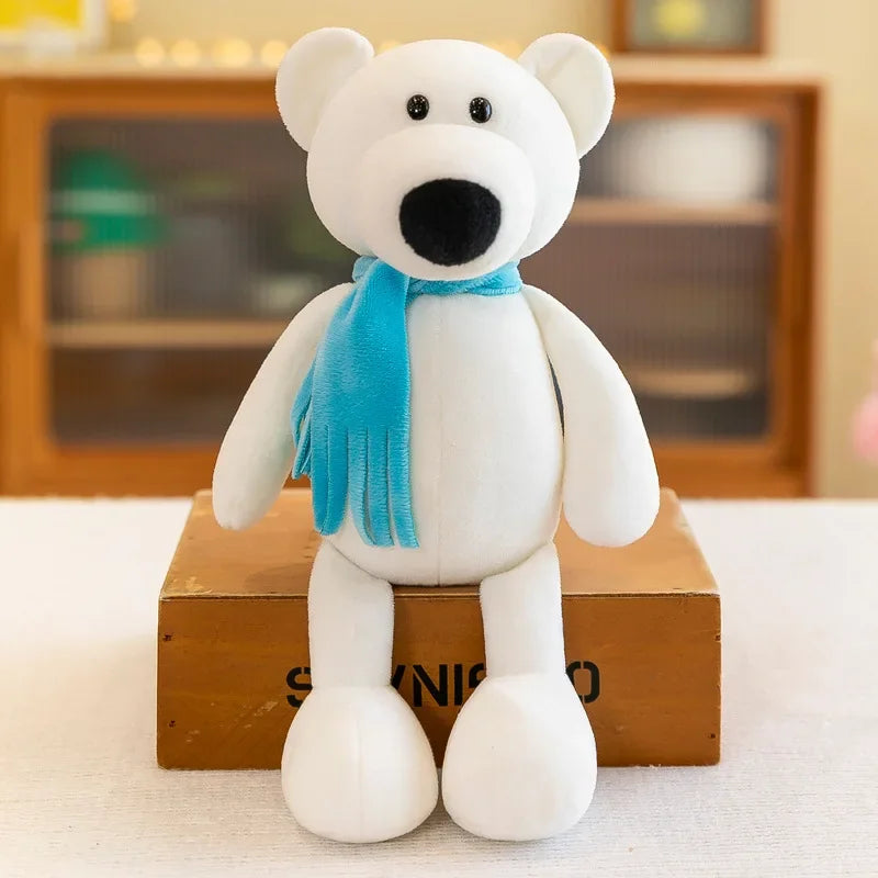 A white teddy bear plush toy wearing a bright blue scarf sitting on a wooden box.