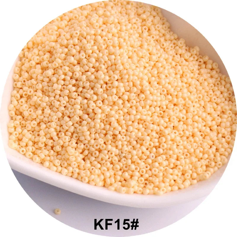 A pile of small, round, pale yellow glass seed beads is shown in a white dish.