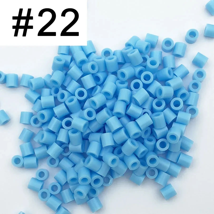 A pile of 1000 small blue plastic fuse beads for creative craft projects.