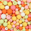 A close-up view of numerous matte acrylic beads in various pastel colors like pink, orange, yellow, and green.