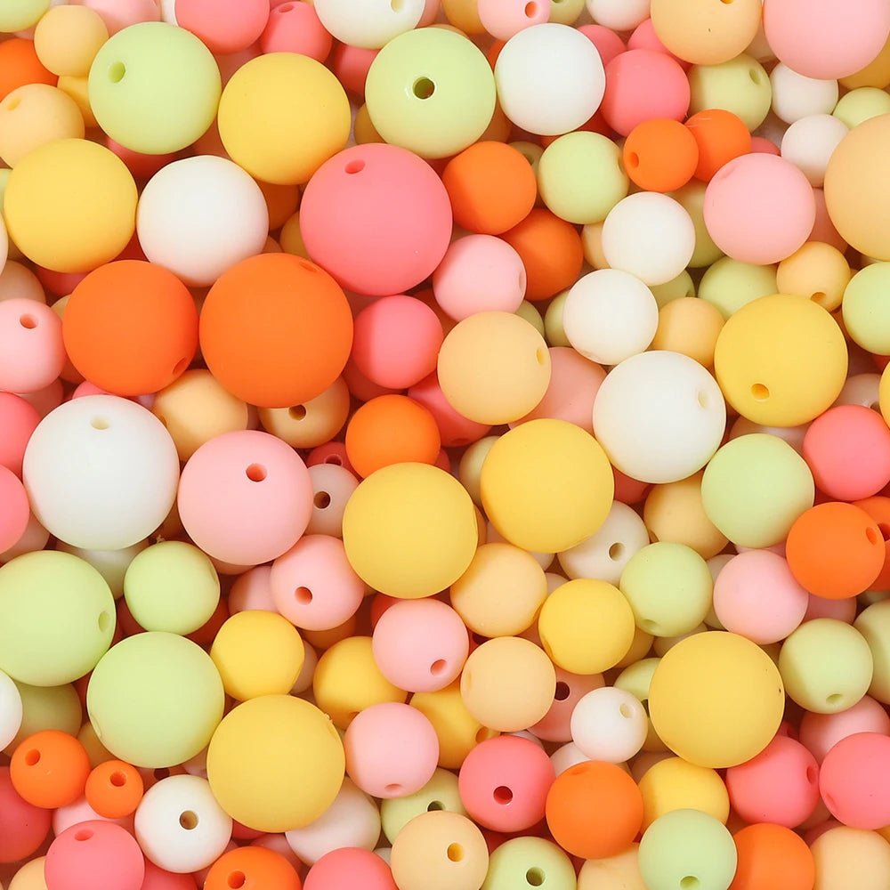 A close-up view of numerous matte acrylic beads in various pastel colors like pink, orange, yellow, and green.