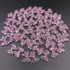 A pile of 20 clear pink acrylic bow beads for jewelry making.