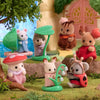 A collection of Sylvanian Families figures including a bear, a rabbit, and a hedgehog in a natural outdoor setting.