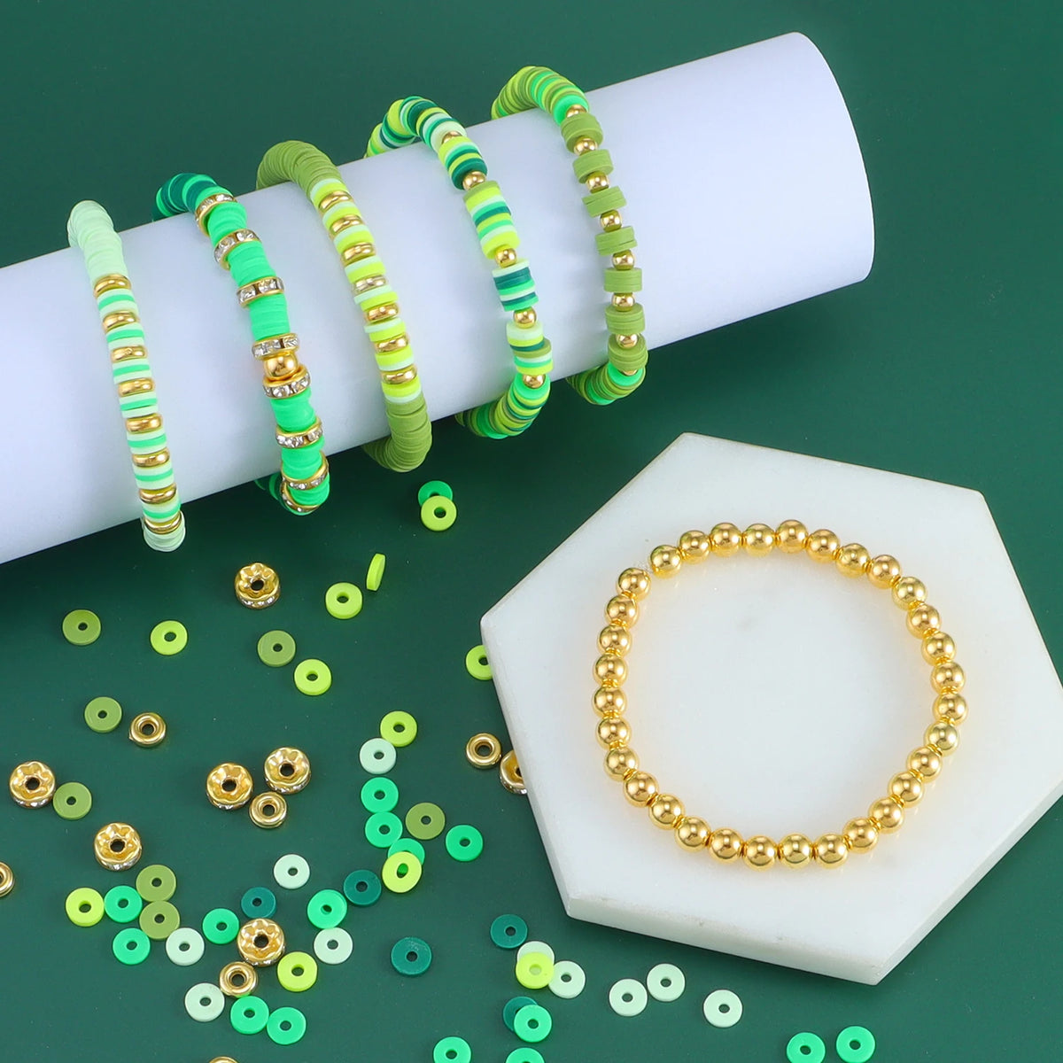 A stack of colorful clay and alphabet beads with a gold bracelet displayed on a white square background.